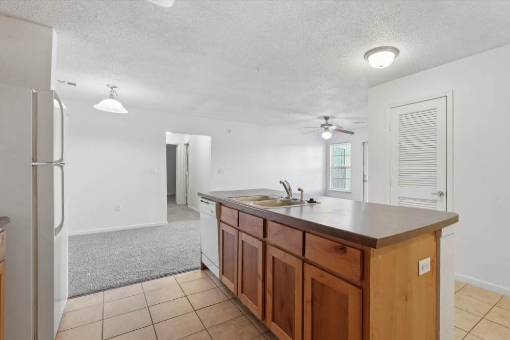 Open kitchen with wooden cabinet at Covington Woods Apartments in Lansing, Kansas
