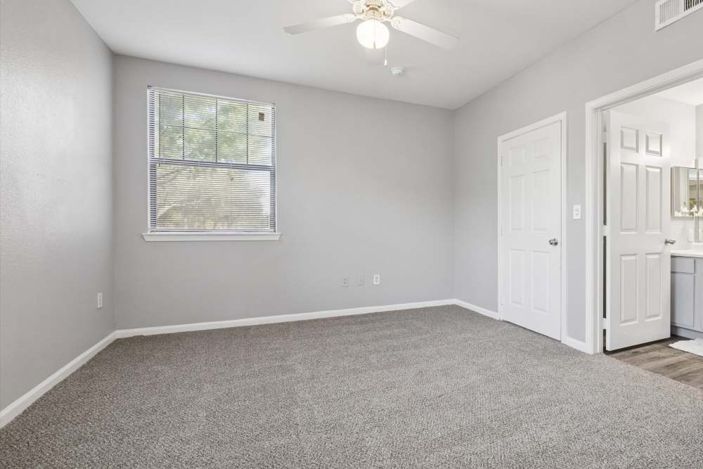 Apartment bedroom with carpet flooring and an attached bathroom at Lansbourough in Houston, Texas