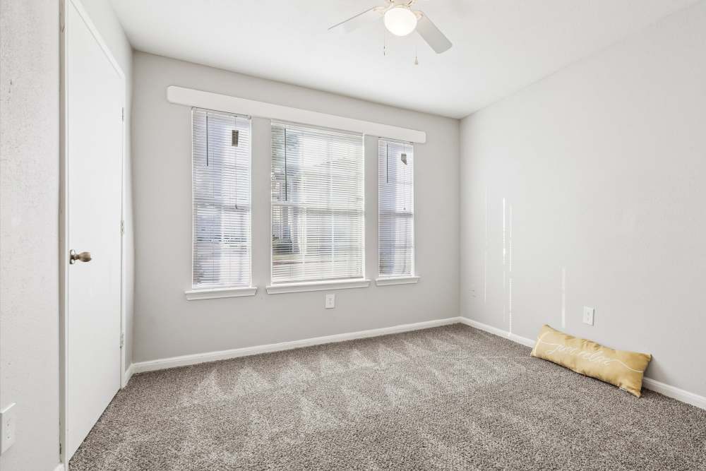Charming bedroom with natural light and cozy carpeting at Scott Street Townhomes in Houston, Texas.