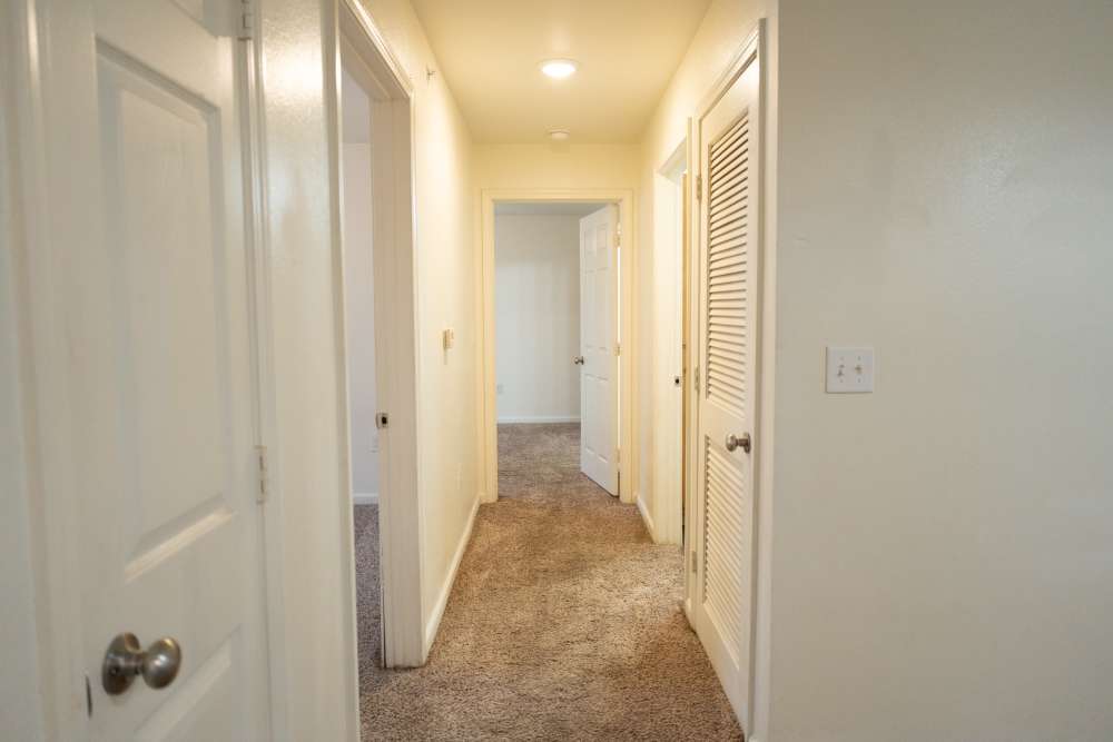 Bright hallway leading to cozy carpeted rooms at Shawnee Park in Shawnee, Oklahoma