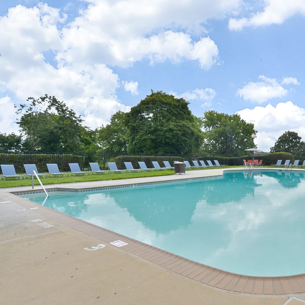 Swimming pool surrounded by lounge chairs at Morningside Apartments & Townhomes in Owings Mills, Maryland