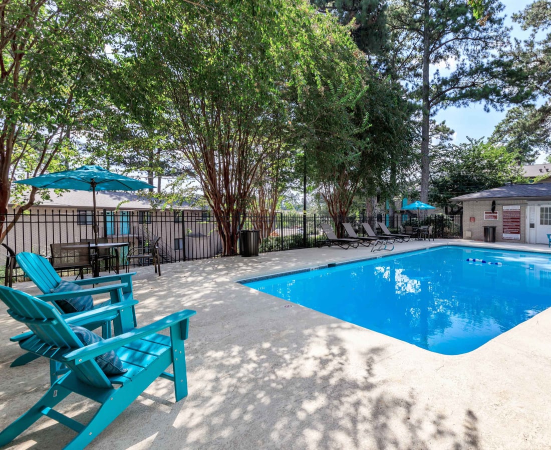 Lounge chairs and covered tables by the pool at Magnolia Gardens in Brookhaven, Georgia