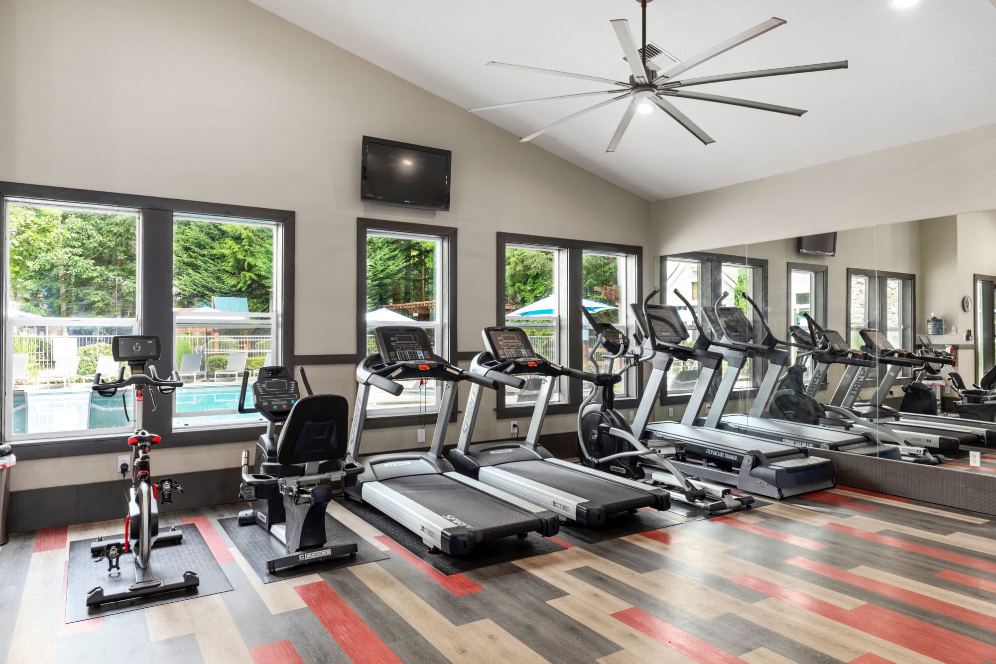 Newly renovated fitness center with views to the pool at Wildreed Apartments in Everett, Washington