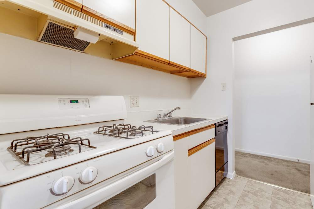 Fully equipped white tone kitchen with gas stove, oven and a dishwasher at Ridgeview Apartment Homes in Reading,Pennsylvania