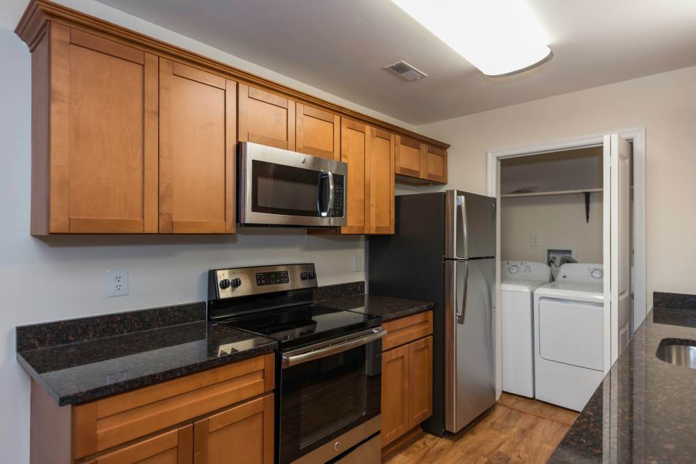 Kitchen with wooden cabinets and the laundry facility at Fox Chase Apartments in Fredericksburg, Virginia