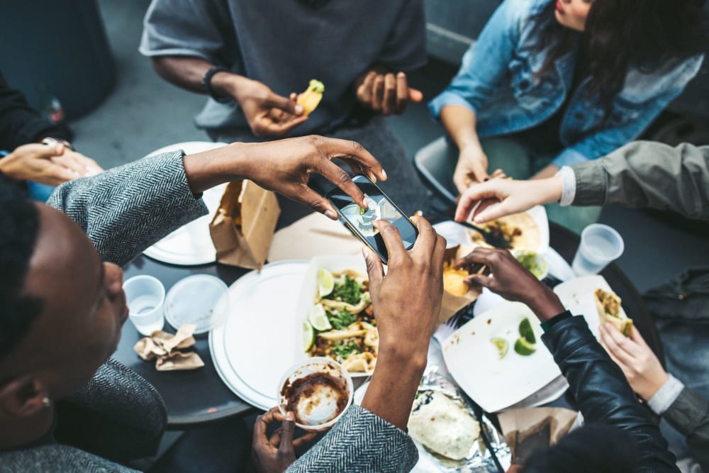 Friends enjoying food from a local restaurant at RISE on Chauncey in West Lafayette, Indiana