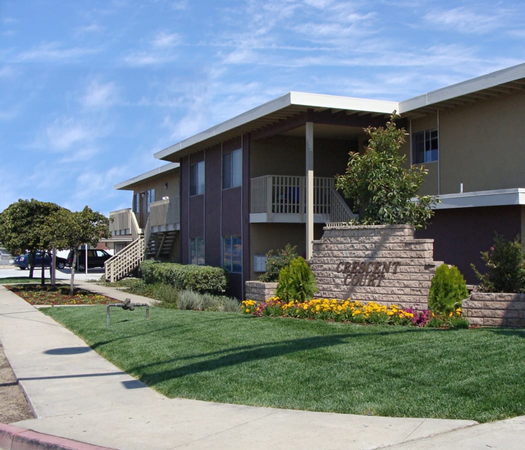 Beautifully grassy lawn and walkway at Crescent Apartments in Marina, California