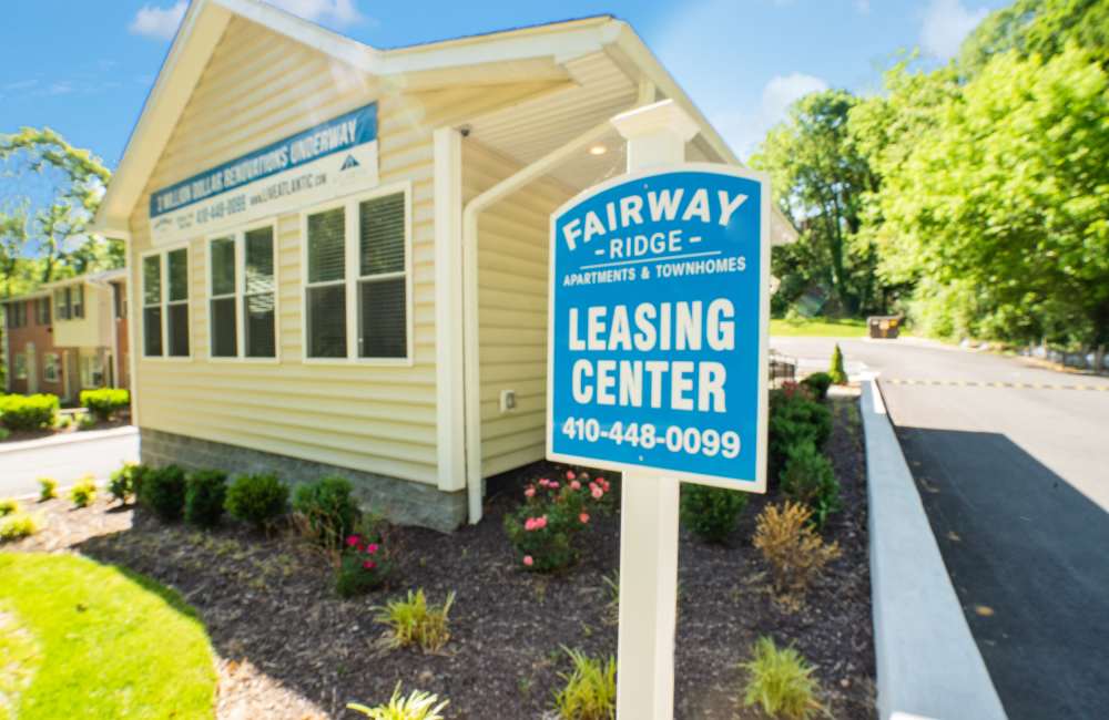 Leasing center with bright signage, landscaped garden, and sunny exterior in a welcoming community at Fairway Ridge in Baltimore, Maryland