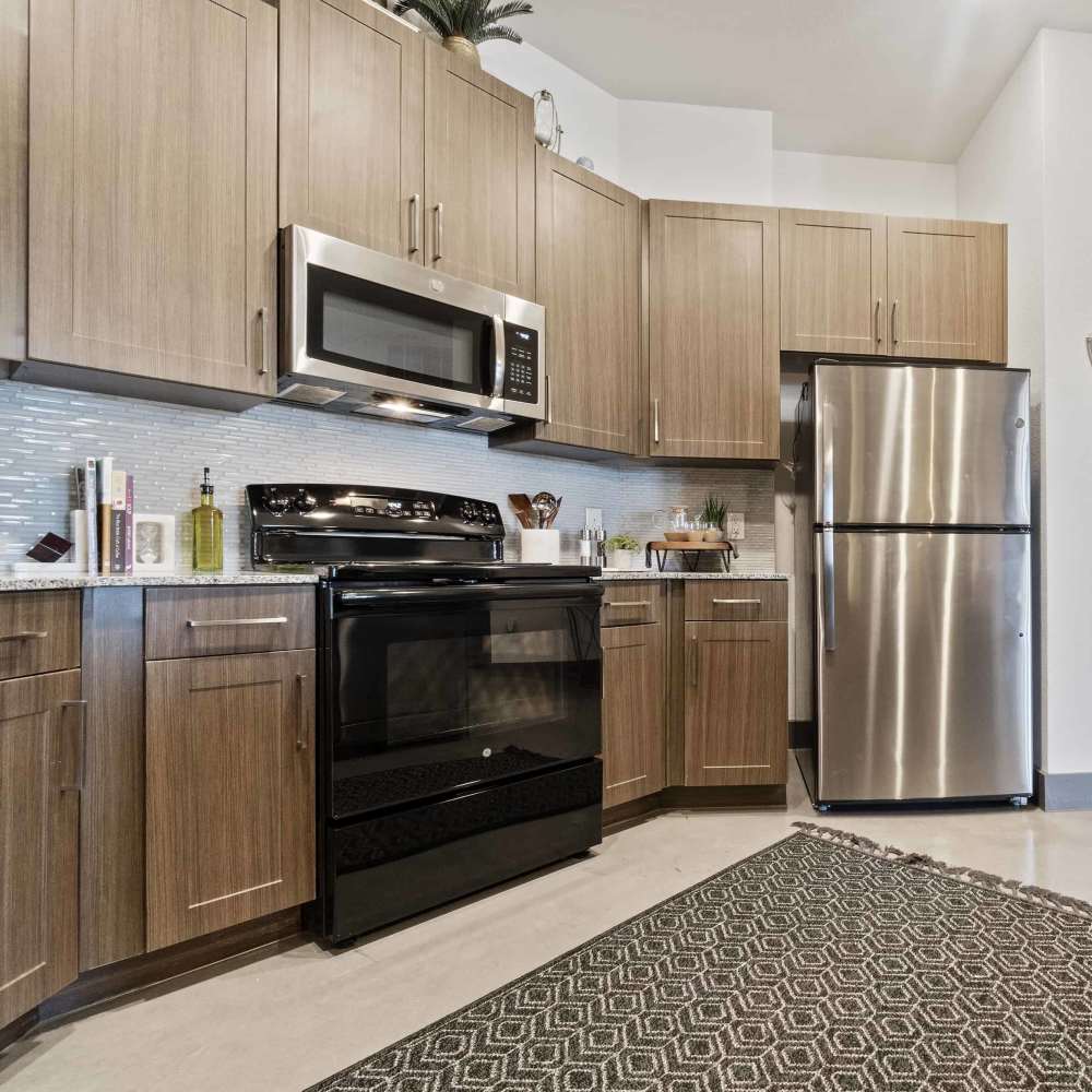 Bright kitchen with range and refrigerator at Millennium Place in Corinth, Texas