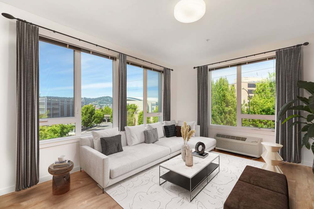 Well-lit living room with comfortable couch and large windows at The Union in Portland, Oregon