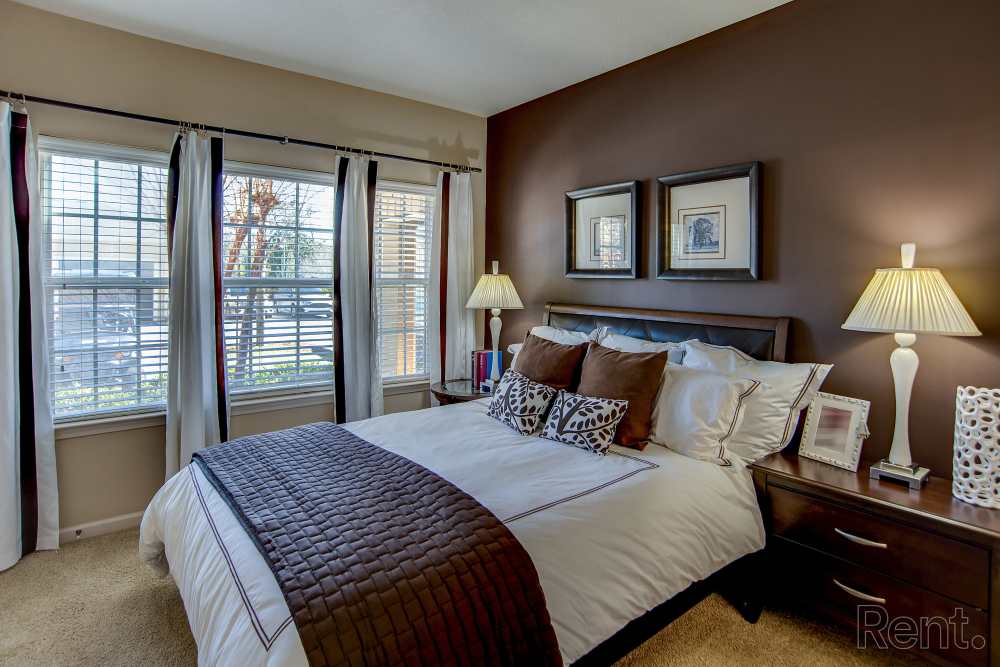 Bedroom with large comfortable bed and window at Highland Hills Apartments in Dothan, Alabama