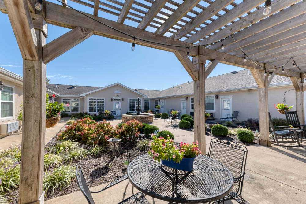 Courtyard with lush flora and paved walkways at Addington Place of Lee's Summit in Lees Summit, Missouri