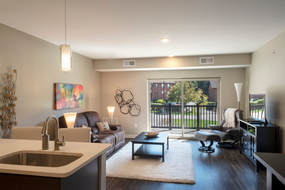 Spacious living room with access to private balcony at Cosmopolitan Apartments in Pittsburgh, Pennsylvania