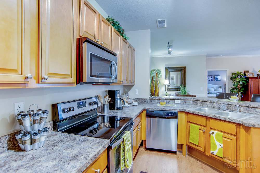 Kitchen with a stove, wooden cabinets at Highland Hills Apartments in Dothan, Alabama