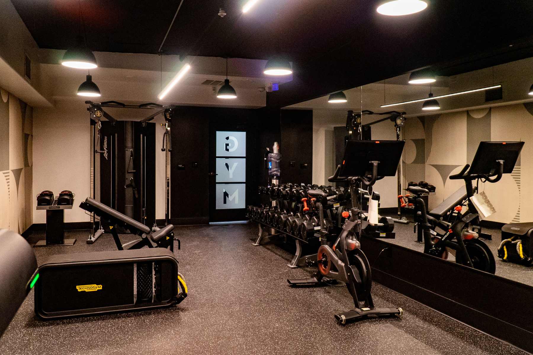 Modern gym with bikes and dumbbells at Luxe Villas in Brentwood, California