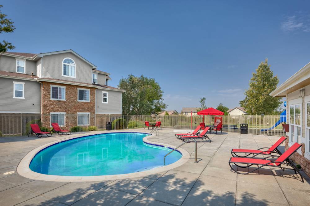 Resort-style swimming pool with lounge seating at Westridge Apartments in Aurora, Colorado