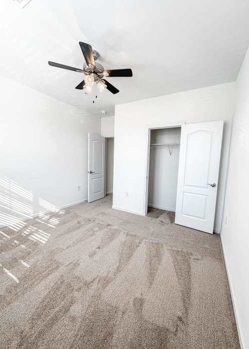 Bedroom with a ceiling fan and a walk-in closet at Windsor Upon Stonecrest in Burlington, North Carolina