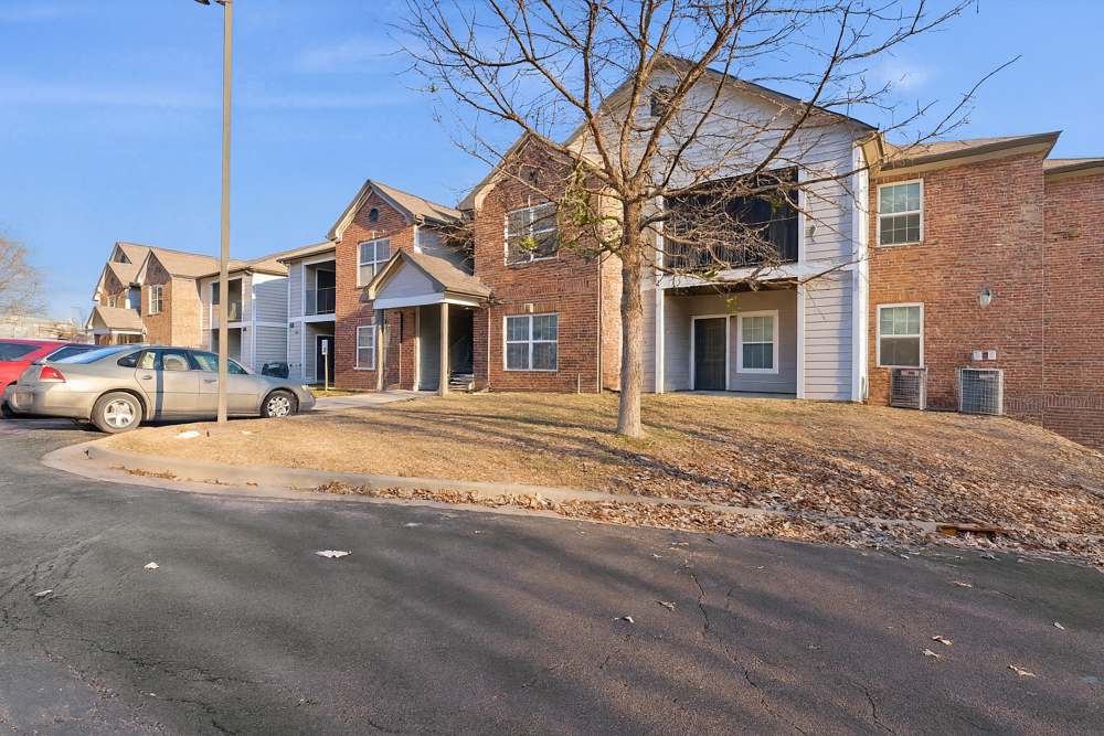 Charming apartment complex with lush landscaping and convenient parking at Covington Woods Apartments in Lansing, Kansas.