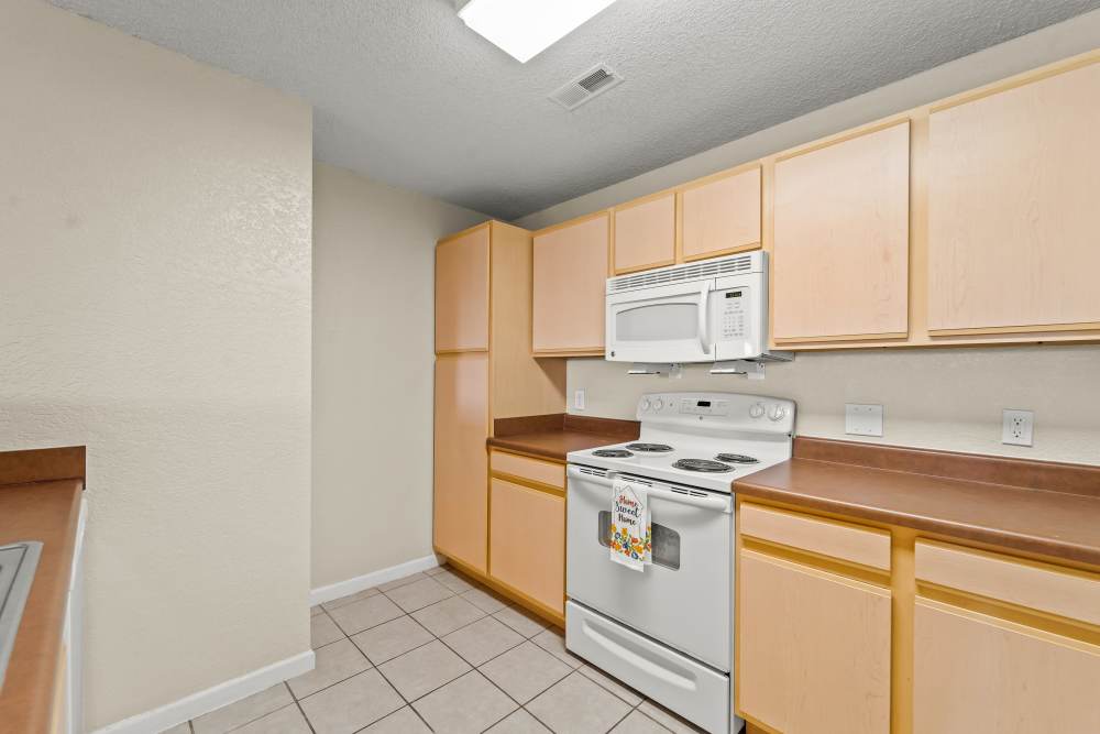 Well-equipped kitchen with wooden cabinets at Callaway Village Phase II in Fulton, Missouri