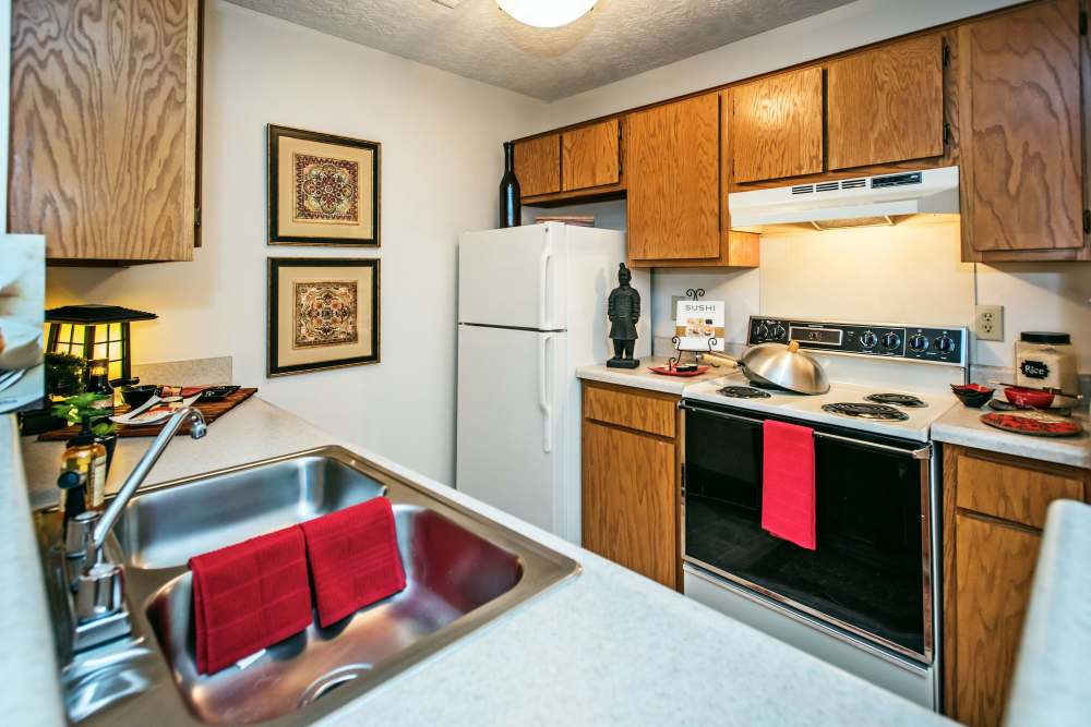 Modern kitchen featuring granite countertops, stainless steel appliances, and wooden cabinetry at Stevens Creek Commons in Augusta, Georgia