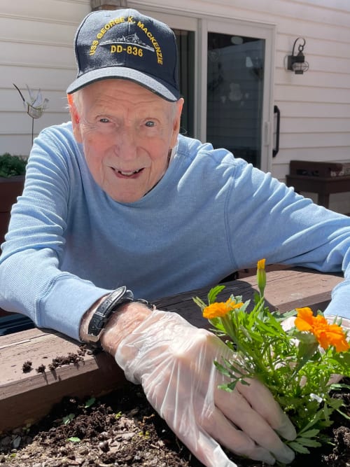 A resident plants flowers in the garden bed at Heritage Hill Senior Community works in the garden