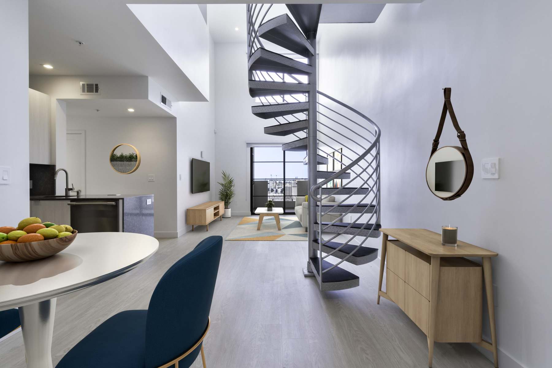 Modern apartment with spiral staircase, white round dining table and cozy living area at Luxe Villas in Brentwood, California