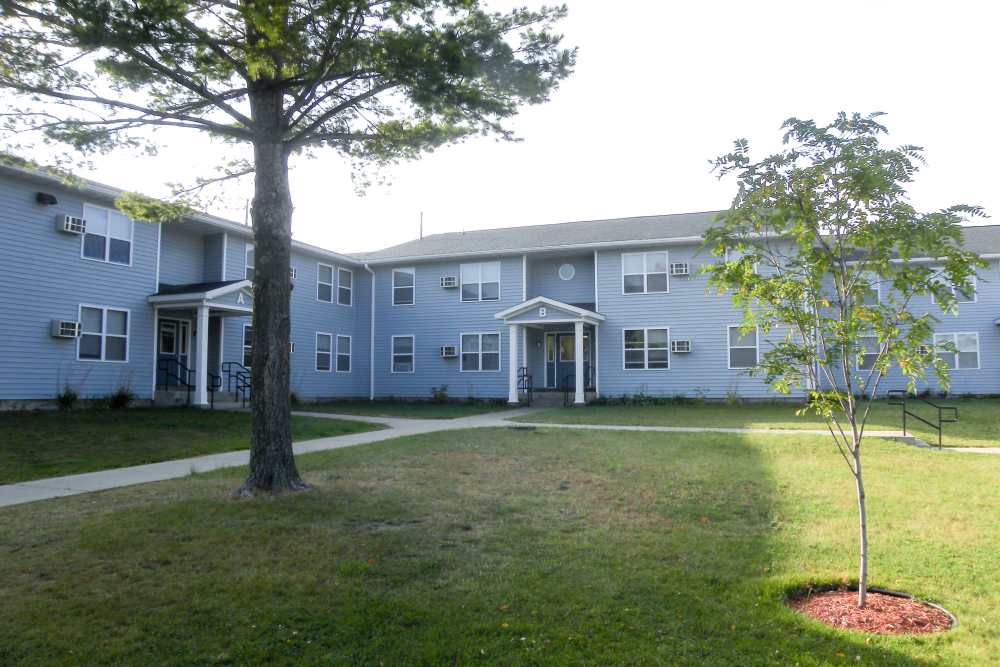 Exterior view of apartments with garden at Manistique Lakeview in Manistique, Michigan