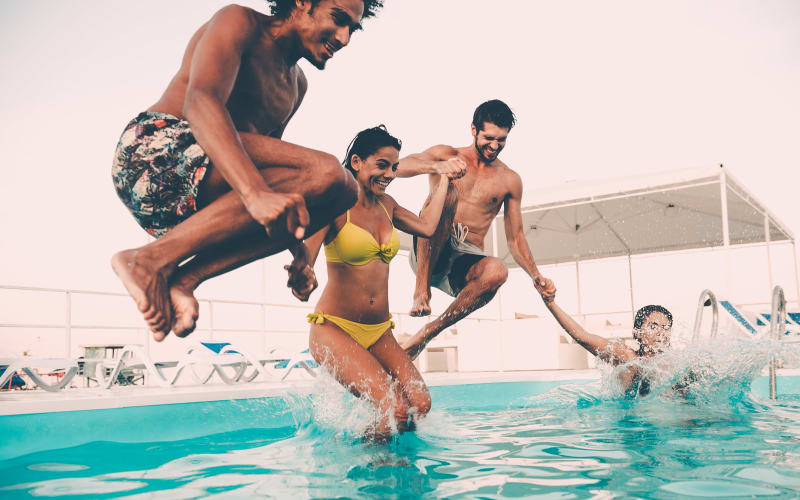 Residents jumping into the pool at Willow Oaks Apartments in Bryan, Texas