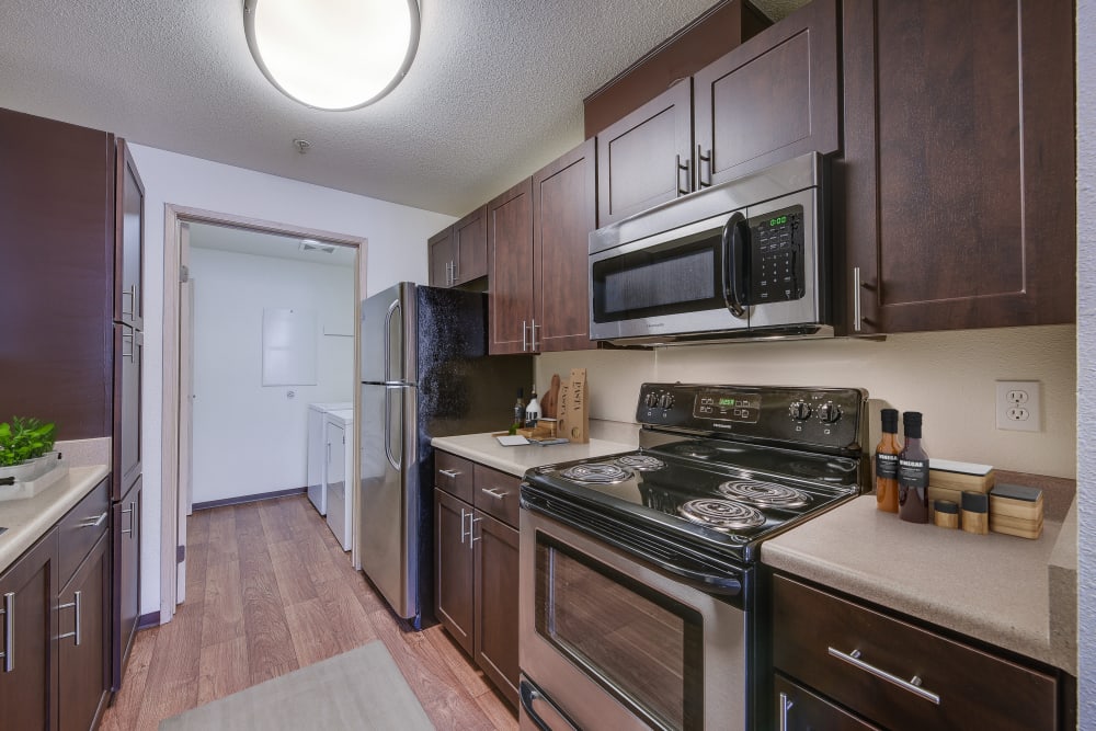 Espresso cabinets in a renovated kitchen with stainless steel appliances at Renaissance at 29th Apartments in Vancouver, Washington
