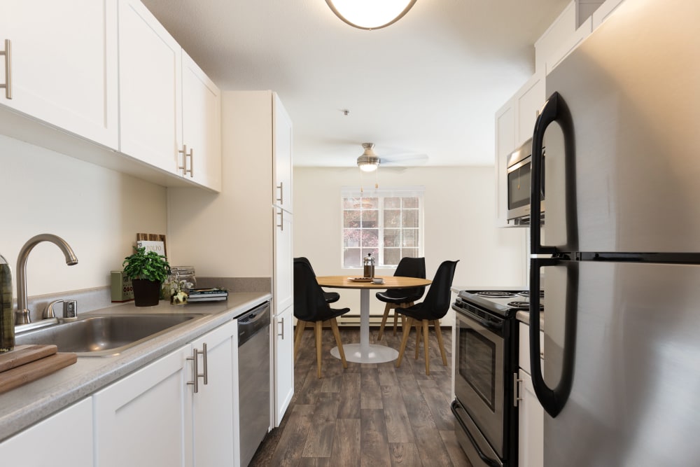 Kitchen and dining room with wood-style flooring at Renaissance at 29th Apartments in Vancouver, Washington