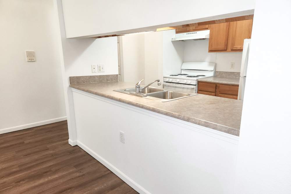 Kitchen with sink and wooden cabinetry at Woodbrook Apartments in Three Rivers, Michigan