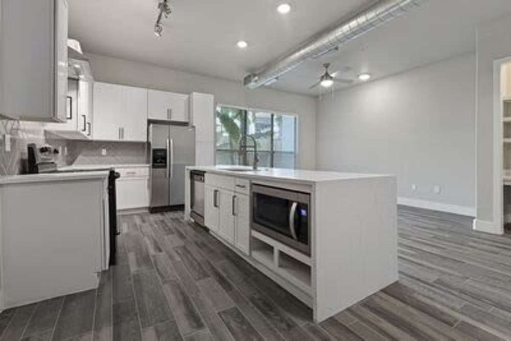 Kitchen showing a microwave oven and a refrigerator at Briar Forest Lofts in Houston, Texas
