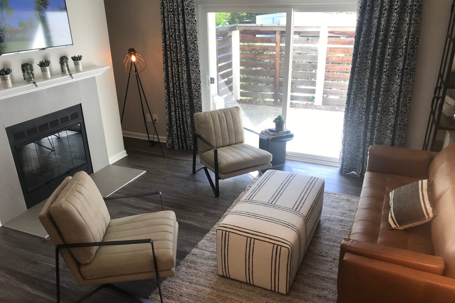 Living rooms with hardwood floors, a fireplace and a private patio at Cotton Wood Apartments in Dublin, California