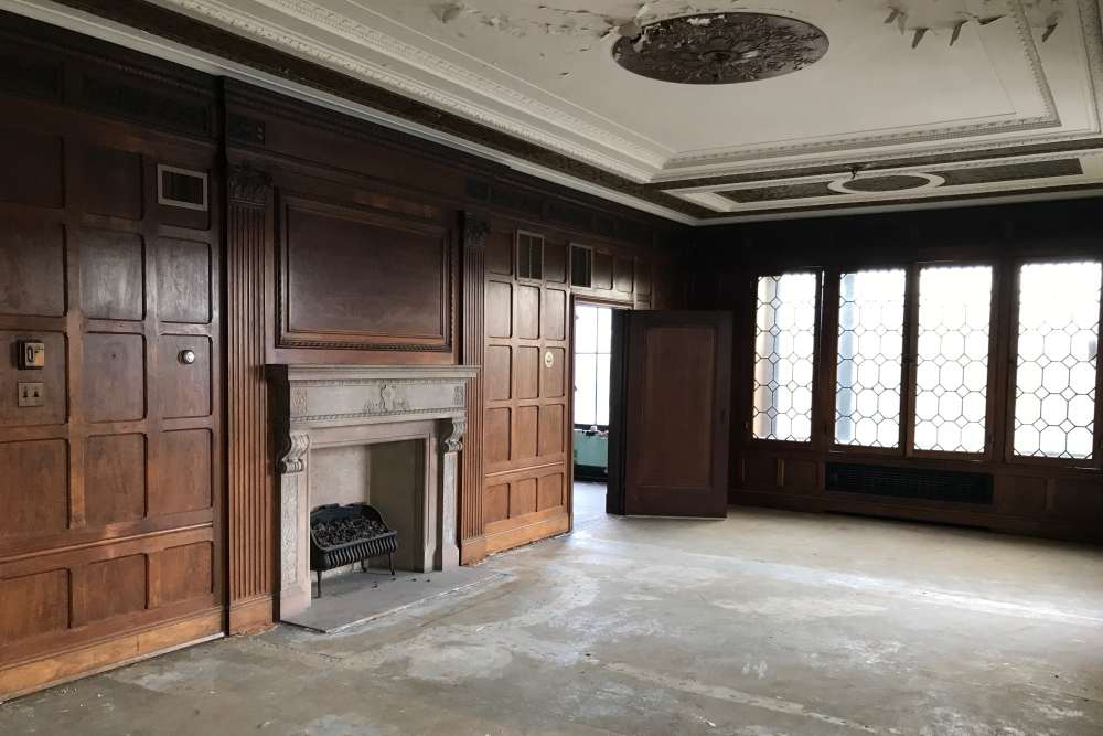 Spacious room with wood-paneled walls and large windows at 43 Town Square in Lima, Ohio