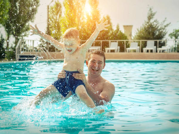 Father and son playing in the pool at TerraLane at Canyon Trails in Goodyear, Arizona