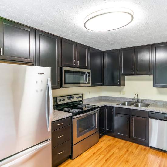 Modern kitchen with wooden cabinets and stainless-steel appliances at Hawthorne Estates in Oakdale, Pennsylvania