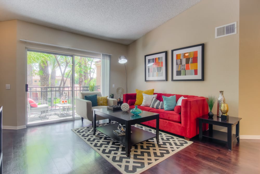 A living room complete with a private patio at Tuscany Village Apartments in Ontario, California