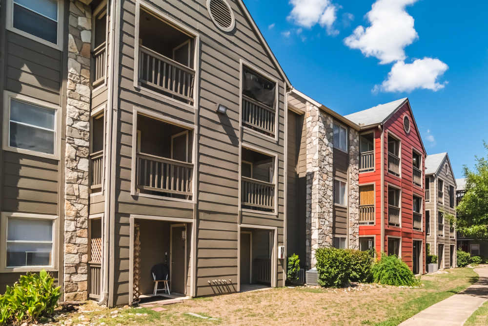 Side view of apartment building with lawn at Villa De Oro in San Antonio, Texas