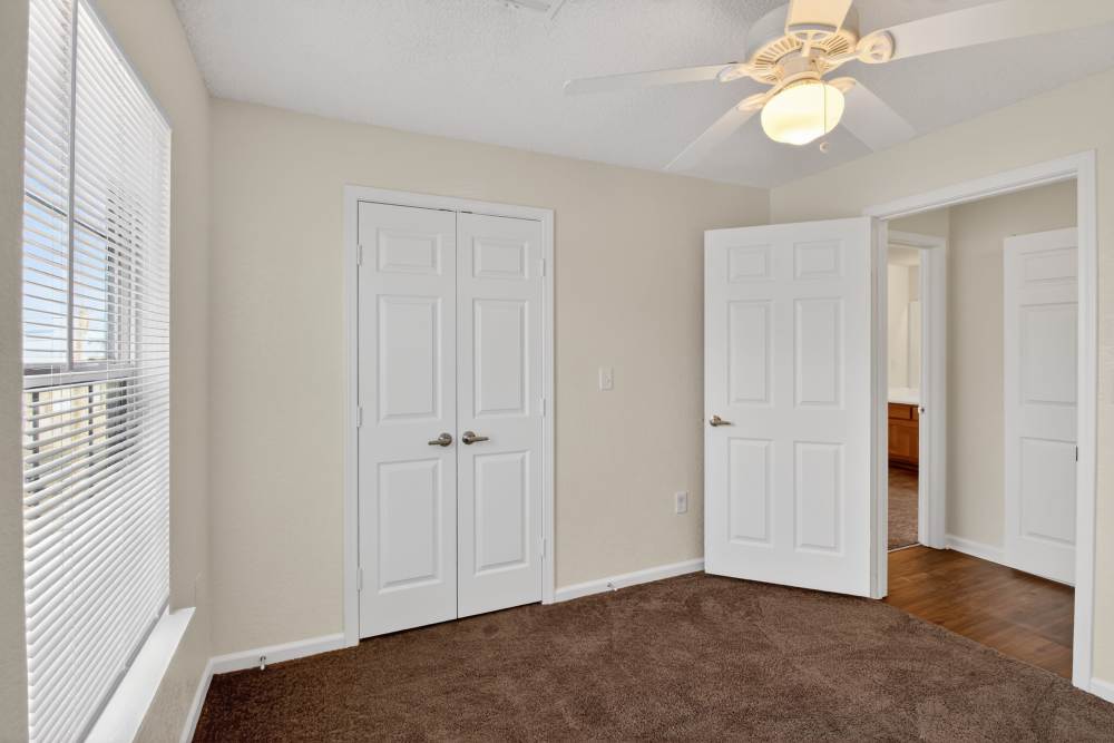 Unfurnished bedroom with ceiling fan and large window at Dunes Apartments in Seminole, Texas