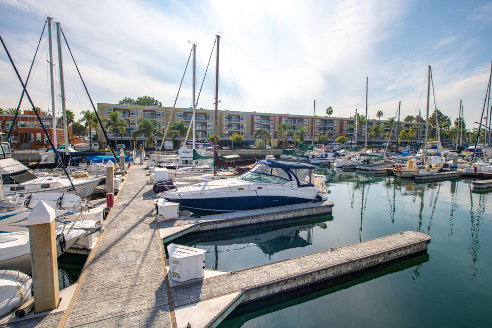 Motorboats and sailboats docked at concrete piers near Harborside Marina Bay Apartments in Marina del Rey, California