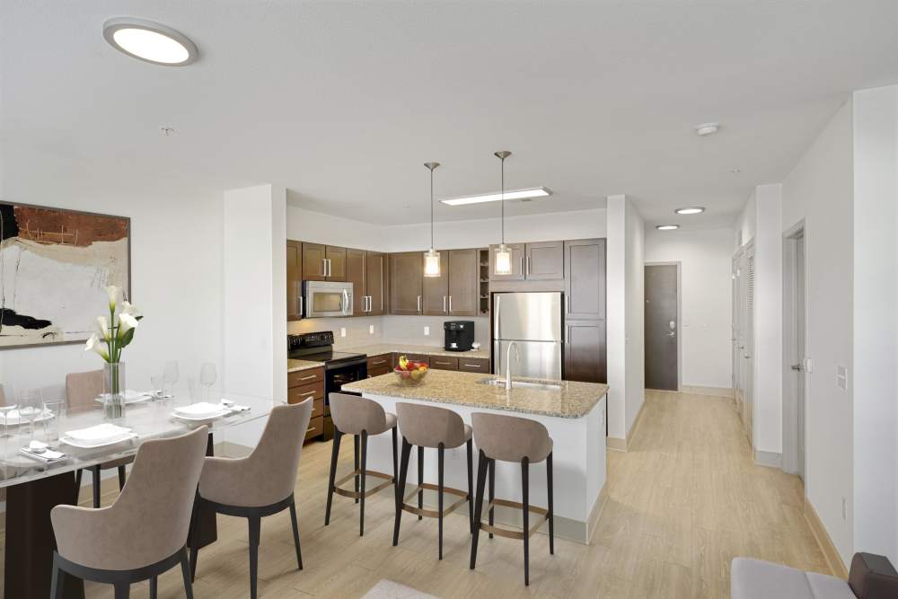 Kitchen with stainless-steel appliances and an island and dining table at Helios in Englewood, Colorado
