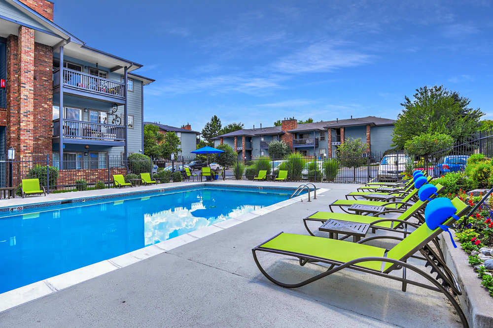 Sparkling pool with lounge chairs at Arapahoe Club Apartments in Denver, Colorado