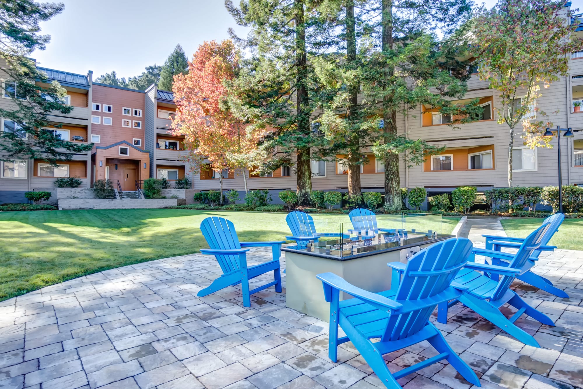 Adirondack chairs around a firepit at Serramonte Ridge Apartment Homes in Daly City, California