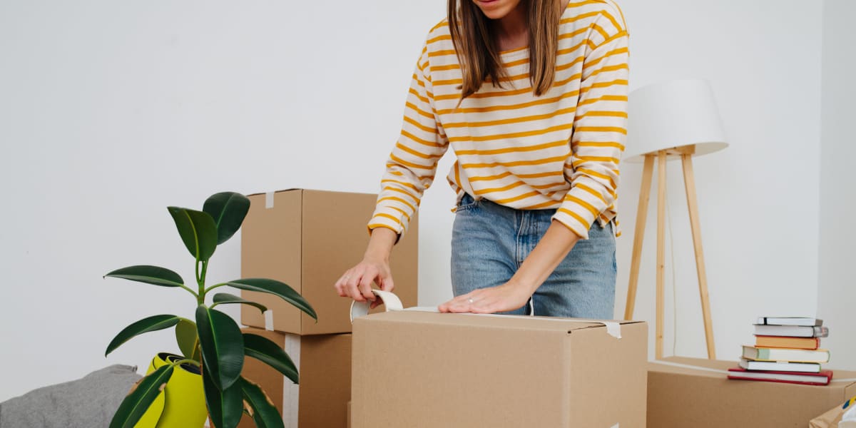 A women taping up a box from A+ Self Storage in Woodburn, Oregon