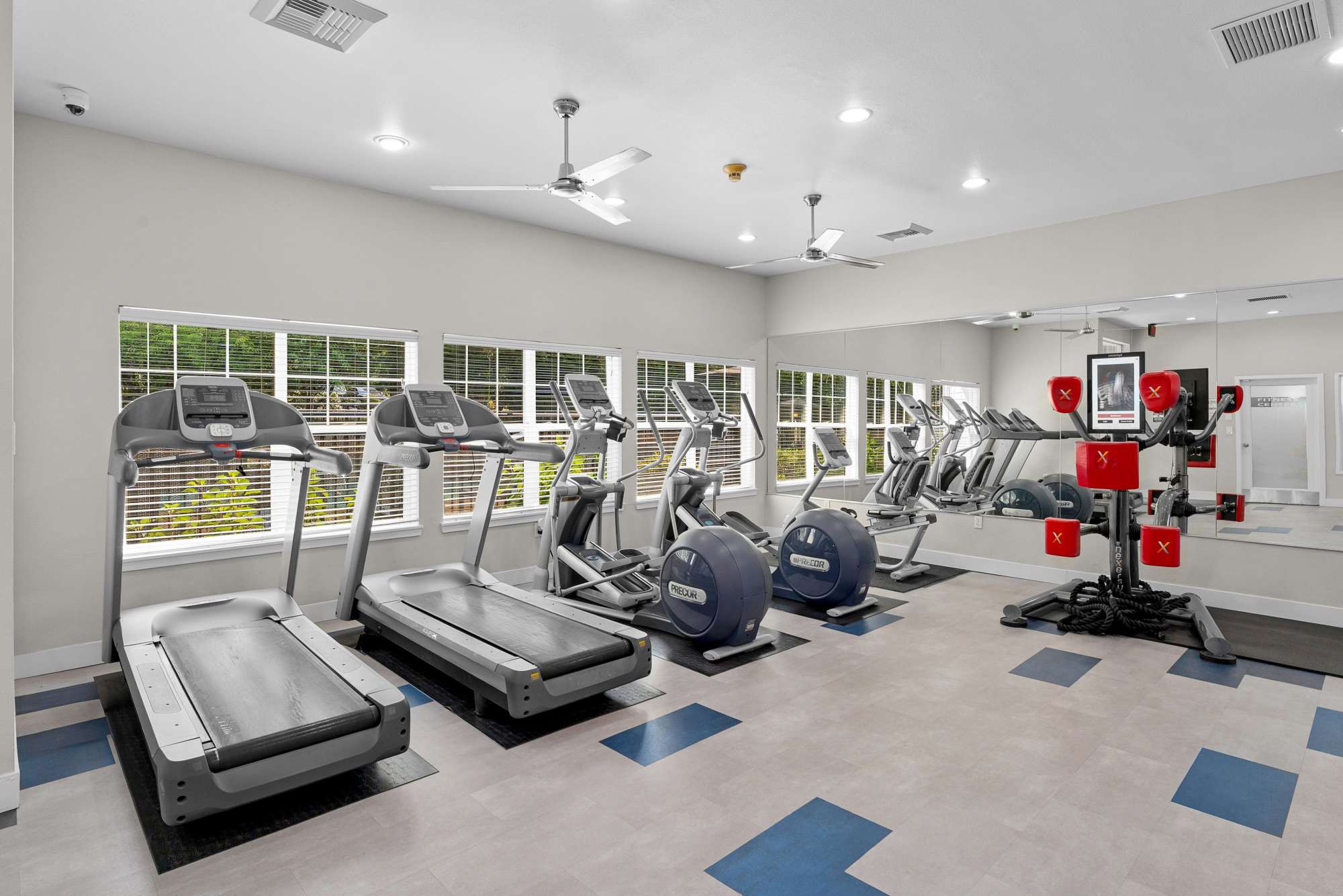 Fitness center with boxing and cardio machines at Pebble Cove Apartments in Renton, Washington