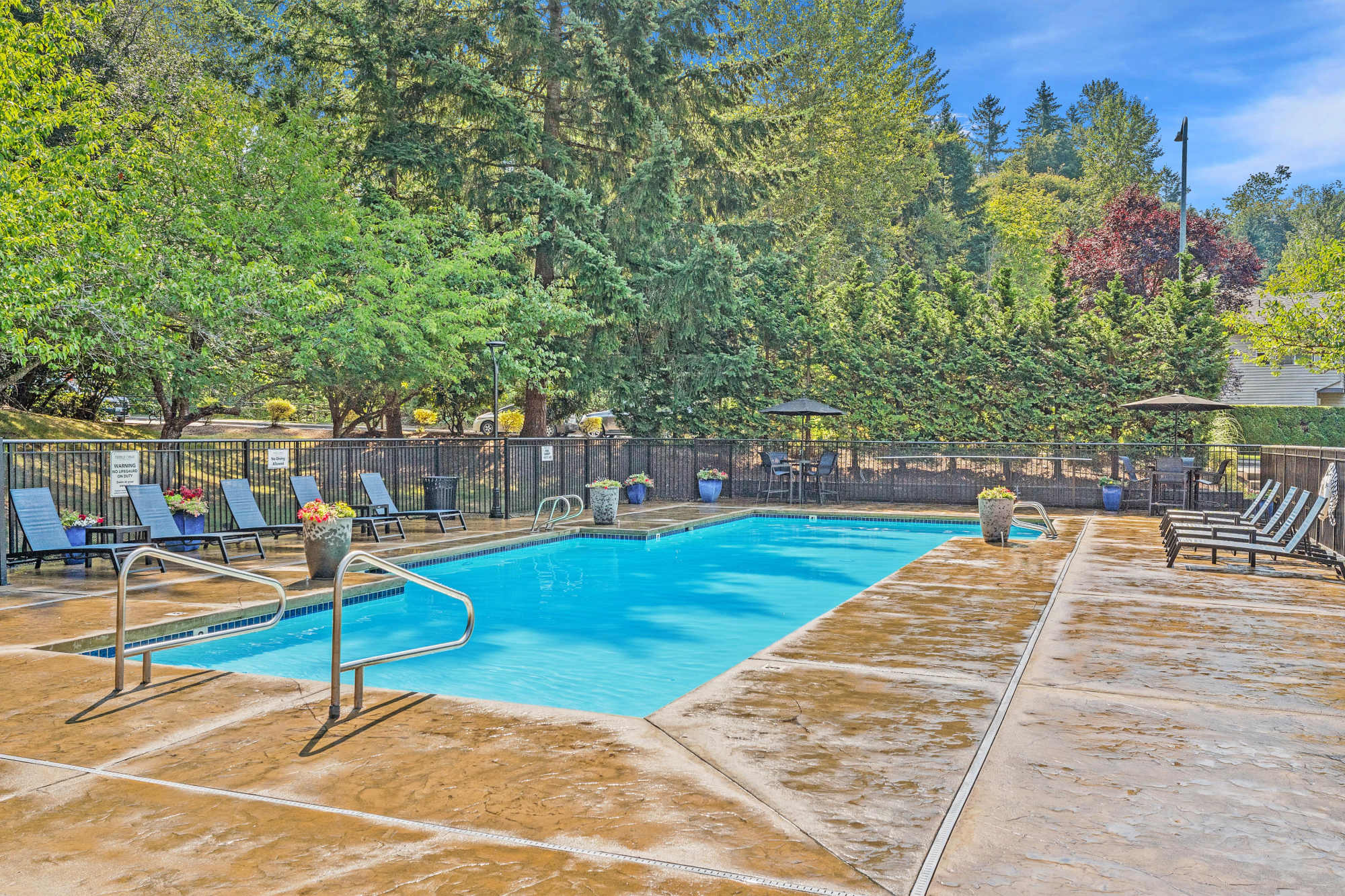 Large bright blue swimming pool at Pebble Cove Apartments in Renton, Washington