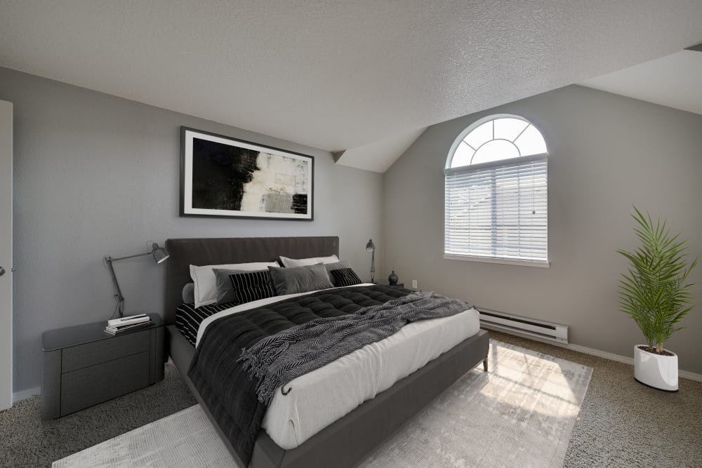 Decorated master bedroom with a large window at Walnut Grove Landing Apartments in Vancouver, Washington