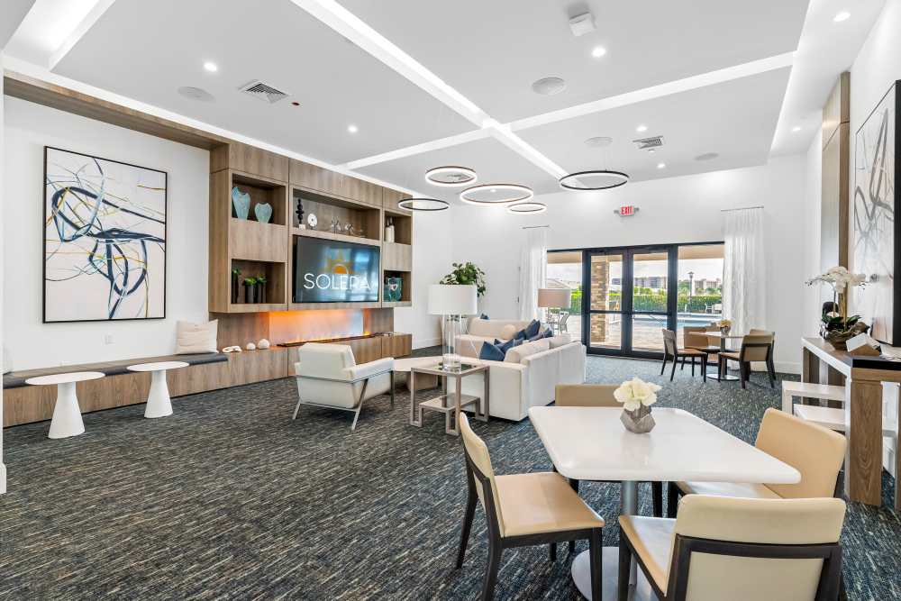 Seating area with a television and artwork at Solera at Avalon Trails in Delray Beach, Florida