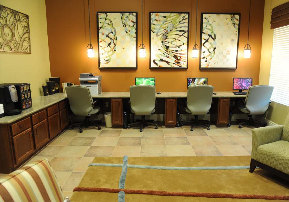 A stylish co-working space featuring modern desks, vibrant artwork, and cozy seating, perfect for productivity in a welcoming atmosphere at Cresta Bella in San Diego, California