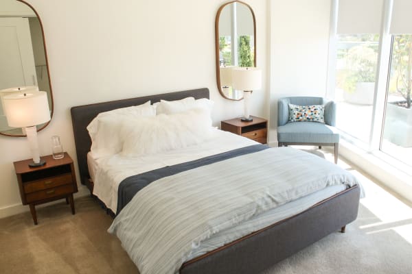 Model bedroom with plush carpeting and floor-to-ceiling windows at One City Center in Durham, North Carolina